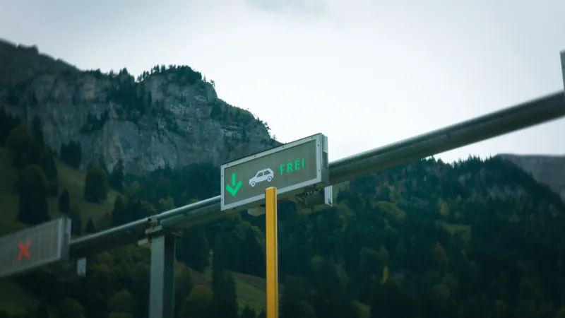 Die grüne Frei-Anzeige der Schranke vor den bewaldeten Berghängen des Melchtals
